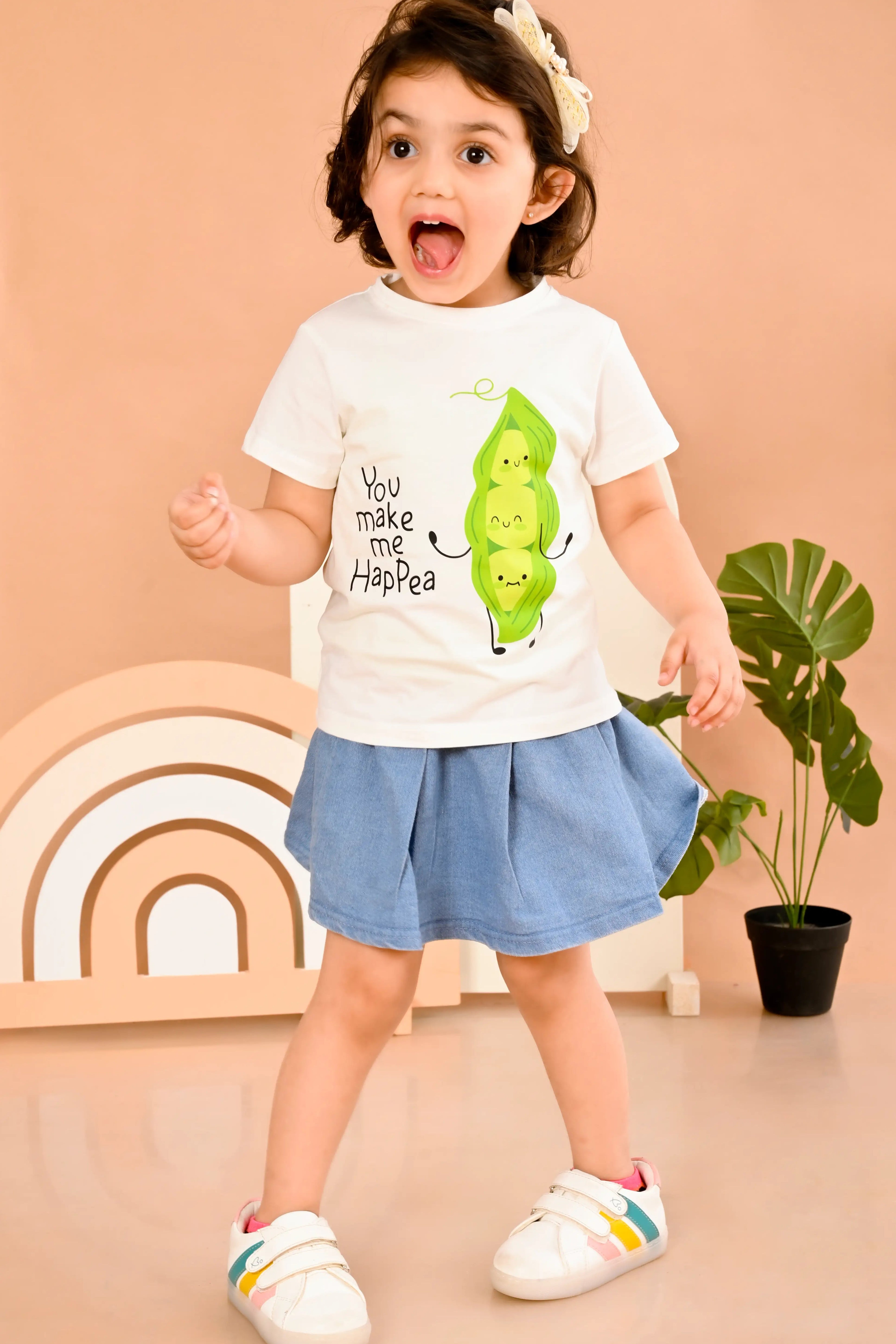 Child wearing a off white t-shirt in 100% pure cotton with a happy pea pod